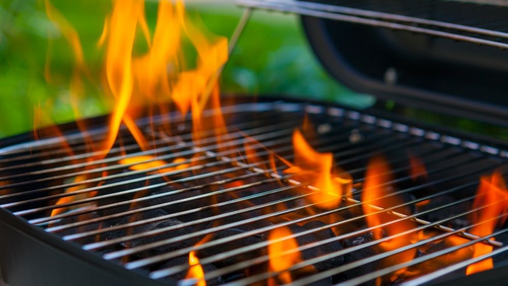 Photo with a grill in flames in a garden in an article on the origin of the grills